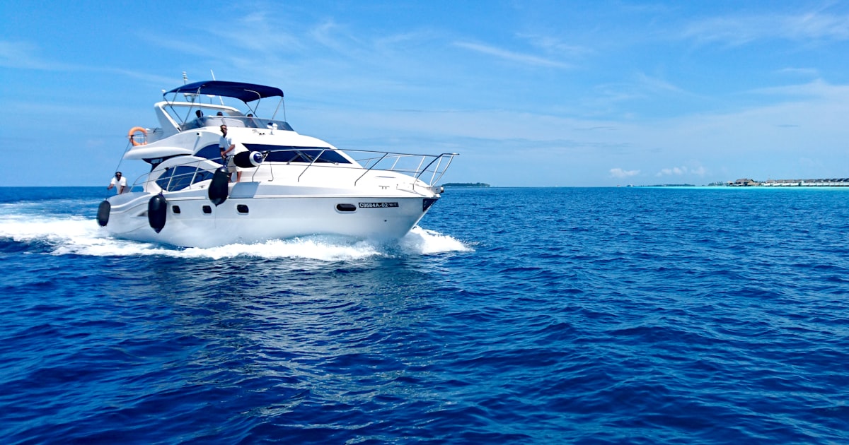 Yate de motor de lujo fondeado en aguas turquesas de Ibiza con invitados disfrutando en cubierta