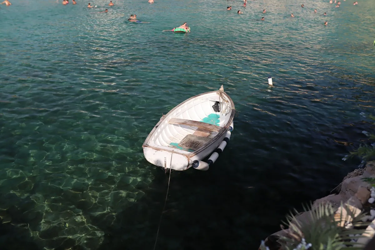 Small license-free boat anchored in a crystal-clear Ibiza cove