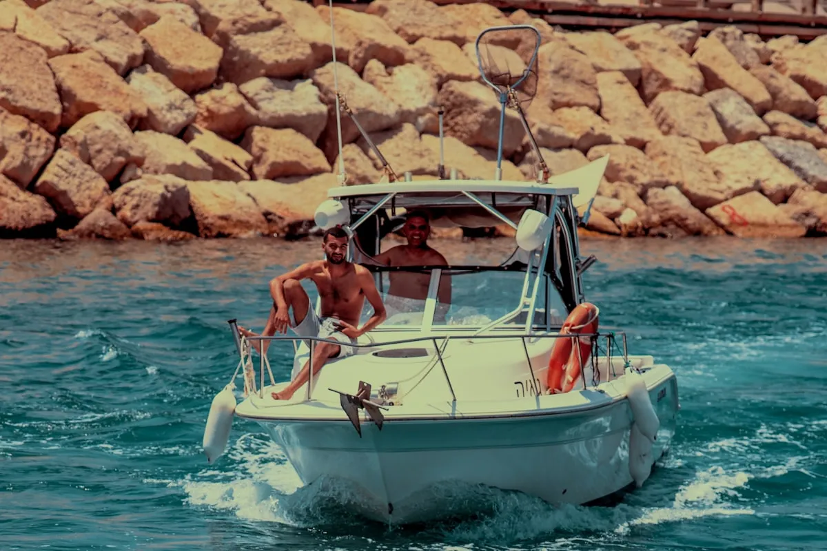 Friends swimming from a charter boat anchored near a beautiful beach